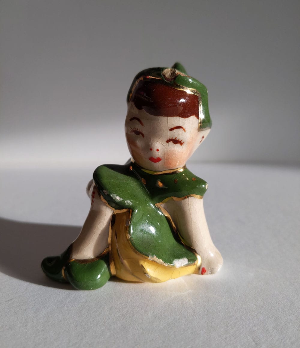 small ceramic figurine in uneven lighting