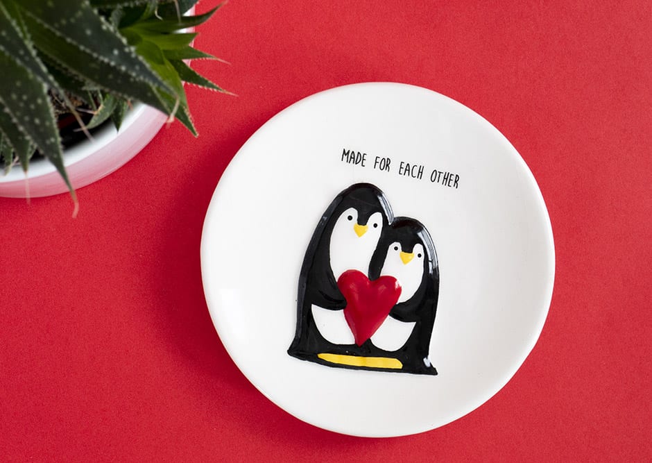 small penguin dish with a plant against red background